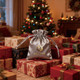 A silver satin drawstring bag with a logo, placed among wrapped gifts in a decorated Christmas setting.