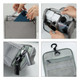 A grey hanging travel toiletry bag with compartments, featuring a hook, zippered pockets, and various travel-sized containers.