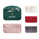 A collection of velvet glasses pouches in green, white, pink, red, and grey, featuring a logo on one pouch.