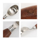 A wood handle ice cream scoop featuring a stainless steel scoop and detailing on the wooden handle.