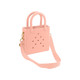 A mini beach bag in soft pink with holes, featuring two handles and a detachable shoulder strap.