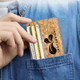 A cork card holder in a pocket, featuring a natural cork texture and a logo design.