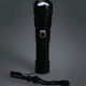 A black LED flashlight with a textured grip and a lanyard, featuring a circular button on its body.