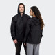 A black windbreaker jacket with a hood, featuring a front pocket and a logo, displayed on two models.