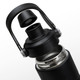 A drink bottle in matte black with a detachable lid featuring a handle and a stainless steel interior.