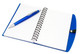 A blue notepad with lined pages and a silver pen resting on top. The notepad features a spiral binding.