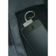 A close-up of a dark blue bag pocket featuring a metallic loop and a sleek phone inside a mesh compartment.