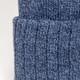 A blue knitted beanie with a folded cuff, showcasing a textured pattern. It features a branding logo.