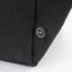 A black cooler bag featuring a logo, made from recycled materials. The textured fabric is visible in the image.