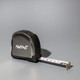 A black tape measure with a retractable white measuring tape and a logo on the side.