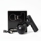 A black mini massage gun beside its box and a charging cable, featuring a sleek design and rounded head.
