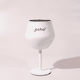 A white Shiraz detachable wine glass with a black interior and a stand, featuring a logo.