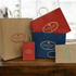An assortment of Navy, Red and Kraft Paper Shopping Bags