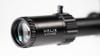 Element Optics Helix 6-24x50 SFP rifle scope, featuring an EHR-1C MOA reticle. The scope's name "HELIX" is clearly etched on the side, set against the durable matte black body of the scope. The photo captures the multi-coated lens which exhibits a hint of blue and green reflections, indicative of high-quality glass designed to enhance light transmission and reduce glare. This detailed perspective emphasizes the craftsmanship and optical quality of the scope, ideal for engaging with precision shooting enthusiasts and hunters in marketing and educational content. The blurred background ensures that the viewer's attention is focused on the product's features.