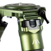 A detailed view of the FatBoy Traverse Tripod's apex, featuring a robust green metallic build with a locking lever and a finely threaded adjustment knob. The precision-machined parts are designed for securing the tripod head and adjusting leg angles. The image captures the complex engineering and quality of the materials, presented against a blurred background to draw attention to the mechanical details.