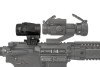 This image features a side view of a Vortex Optics Micro3x Magnifier mounted on a rifle, paired with a red dot sight in front. The magnifier is attached to the rifle with a flip mount, which allows the magnifier to be quickly swung to the side, leaving the red dot sight unobstructed for close-range engagements. The setup shown is a typical configuration for a tactical or sporting rifle where the user requires the versatility of both close and extended range target acquisition. The magnifier enhances the effectiveness of the red dot sight by tripling the sight picture, making distant targets easier to see and engage accurately.