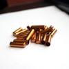 Sierra Jackets for bullet reloading, 6mm size with a length of .825 inches, quantity 1,000. This image displays a pile of shiny copper bullet jackets on a white background, designed for precision bullet assembly. These jackets are essential components for handloading enthusiasts looking to custom-manufacture their own high-performance ammunition for competitive shooting and hunting.