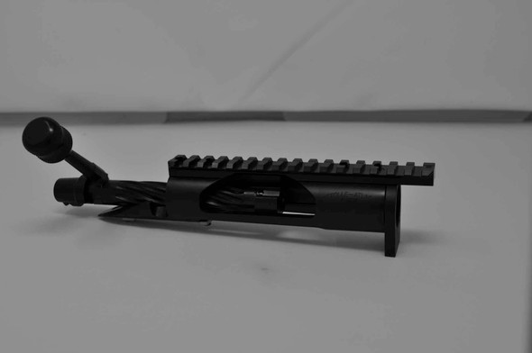 Profile view of the Kelbly Atlas Tactical long action bolt assembly in black nitride finish, designed for Magnum calibers. This assembly features a 1.35-inch round right-hand bolt with spiral fluting and a tactical knurled knob. It supports magazine loading and standard right-side ejection. Additionally, it's equipped with a Picatinny rail providing a 20 MOA elevation and a securely pinned lug, offering robustness and precision for tactical shooting scenarios.