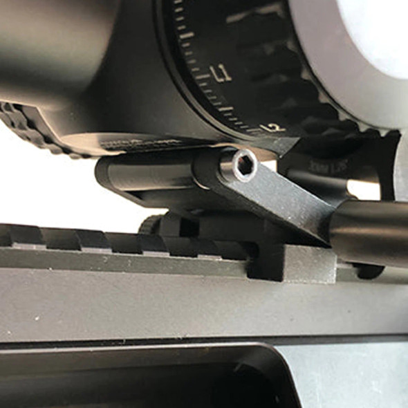 Close-up view of the Fix It Sticks Scope Jack in use, a black mechanical tool designed to precisely adjust the elevation of a rifle scope for accurate leveling, attached to the firearm's rail.