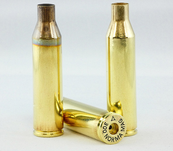Three 300 Norma Magnum rifle cartridges from ADG Brass displayed against a light background. Two cartridges stand upright, showcasing their elongated brass casings and bullet tips, while the third lies horizontally to highlight the headstamp and anneal line. Ideal for ammunition collectors and product listings emphasizing the quality and specifications of ADG Brass in a 50-piece box set.