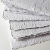 Artway Indigo Seed Paper — close-up of stacked sheets showing deckled edges and seed flecks