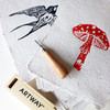 Navy swallow and red toadstool lino prints on Artway Indigo Seed Paper