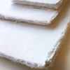 Artway Indigo handmade cotton rag paper, corners of a stack of smooth texture sheets
