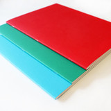 Artway A4 softback sketchbooks stacked in red, green and blue, showing the stapled spine binding