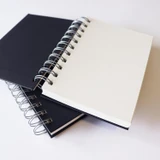 Artway Studio A6 Portrait Spiral Bound Sketchbook open to a blank page, resting on the second book of the twin pack