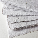 Artway Indigo Seed Paper — close-up of stacked sheets showing deckled edges and seed flecks