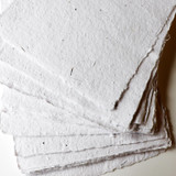 Artway Indigo Seed Paper — fanned sheets showing the speckled, rustic cotton surface