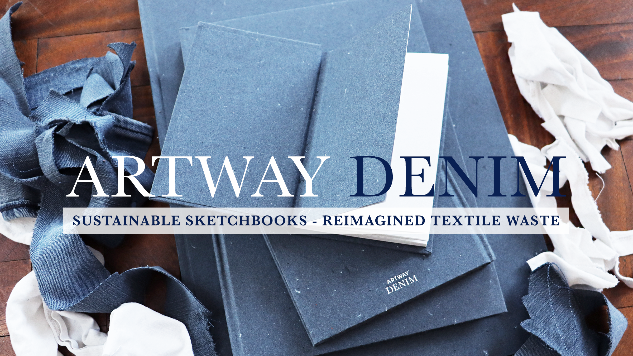 Artway recycled denim sketchbooks with naturally blue denim covers surrounded by denim and cotton off-cuts