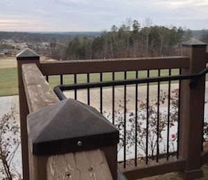 Dark brown weathered copper pyramid post cap on a deck post