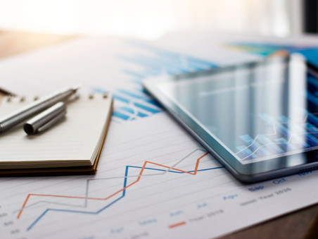 Business document report on paper and tablet with sales data and financial business growth graph on table background.