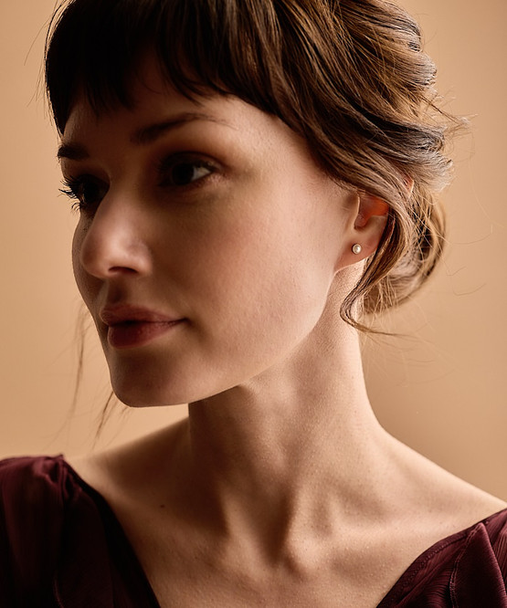 Model wearing the Hypoallergenic Golden Titanium 5mm Bezel White Pearl Earrings