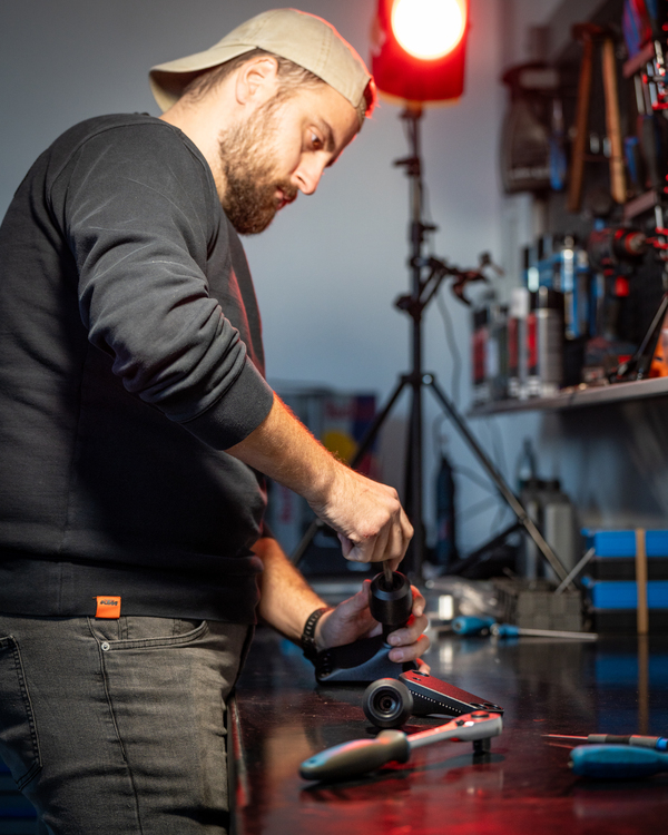 Worker assembling the crash-bobbins on a table inside a workshop. 