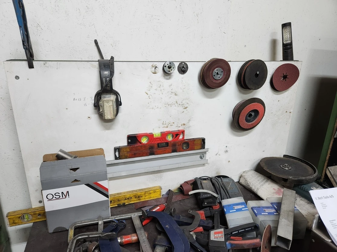 Van storage system with poorly organized compartments, leaving large areas of usable space empty while tools and equipment have fallen onto the van floor, creating clutter and reducing efficiency.