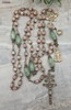 Unique antique-style heirloom rosary featuring solid bronze medals of a radiant Fatima center, sun medal associated with miracles, and a symbolic Miraculous Mary with a snake under her feet, crafted with peach moonstone and green strawberry quartz beads for Catholic devotion and prayer.