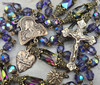 Unique antique-style heirloom rosary featuring solid bronze medals of Jesus, Sacred Heart of Jesus, and the Holy Eucharist, crafted with genuine Austrian Swarovski tanzanite and heliotrope Aurora Borealis crystals for Catholic prayer and devotion.