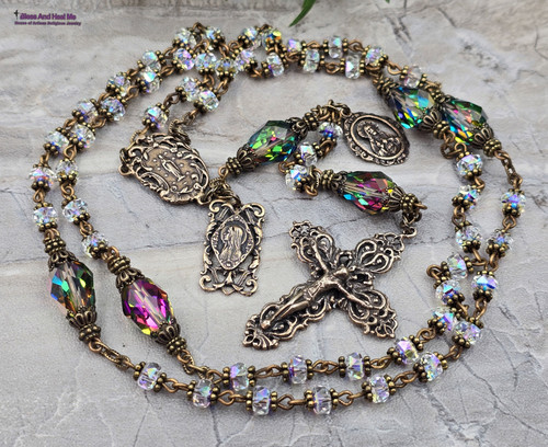 Unique antique-style heirloom rosary featuring solid bronze medals of Our Lady of Lourdes, Blessed Virgin Mary Rosa Mystica, and Sacred Heart of Jesus, crafted with genuine Austrian Swarovski clear Aurora Borealis and vitrail crystals for Catholic prayer and devotion.