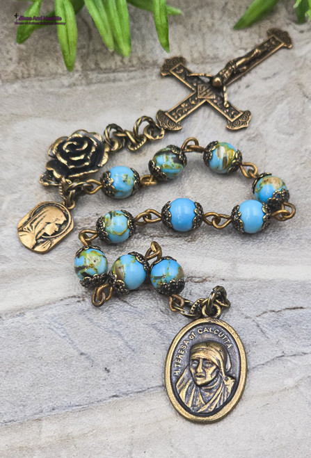 One-of-a-kind antique-style heirloom chaplet with solid bronze medals of Mother Teresa and the Blessed Virgin Mary, crafted with luminous blue beads