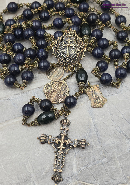 Here's a concise and descriptive image alt text line that incorporates relevant keywords for better Google SEO:

Vintage bronze rosary with 12mm blue sandstone beads, featuring Joan of Arc, St Michael, and St Raphael medallions, perfect for Catholic prayer and devotion.