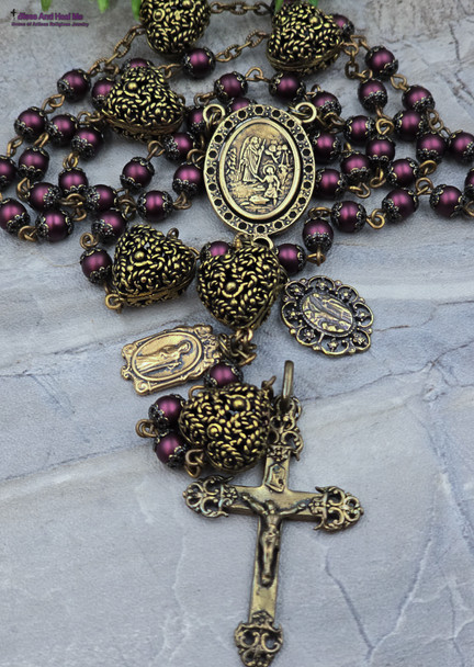 Antique-style bronze rosary with plum pearl shell beads, featuring Archangel Raphael, Our Lady of Lourdes, and St. Jude medallions for Catholic devotion.