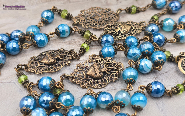 Unique antique-style heirloom rosary with blue mystic agate and peridot beads, featuring solid bronze medals of Our Lady of Guadalupe, Sacred Heart of Jesus, Our Lady of the Rosary, and sun and moon symbols for Catholic devotion.