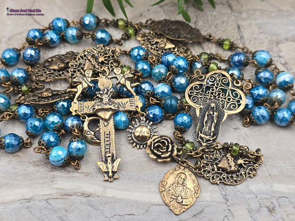 Unique antique-style heirloom rosary with blue mystic agate and peridot beads, featuring solid bronze medals of Our Lady of Guadalupe, Sacred Heart of Jesus, Our Lady of the Rosary, and sun and moon symbols for Catholic devotion.