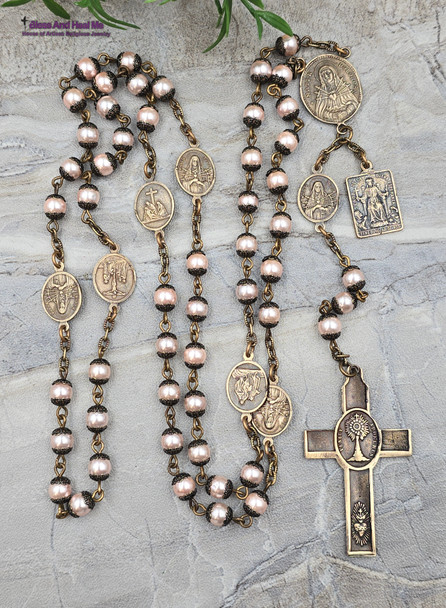 Devotional chaplet with peach pearl shell beads and solid bronze medals featuring the Seven Sorrows, Seven Dolores, Pieta, Lord of Good Hope, Crown of Thorns, Holy Sacraments, and Sacred Heart of Jesus for Catholic prayer and meditation.