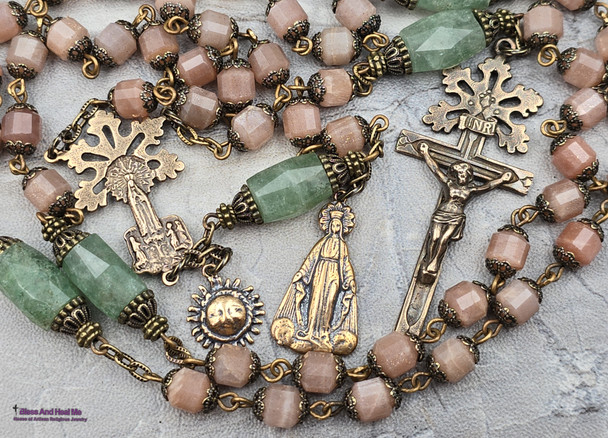 Unique antique-style heirloom rosary featuring solid bronze medals of a radiant Fatima center, sun medal associated with miracles, and a symbolic Miraculous Mary with a snake under her feet, crafted with peach moonstone and green strawberry quartz beads for Catholic devotion and prayer.