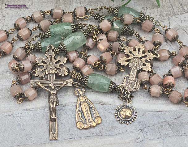 Unique antique-style heirloom rosary featuring solid bronze medals of a radiant Fatima center, sun medal associated with miracles, and a symbolic Miraculous Mary with a snake under her feet, crafted with peach moonstone and green strawberry quartz beads for Catholic devotion and prayer.