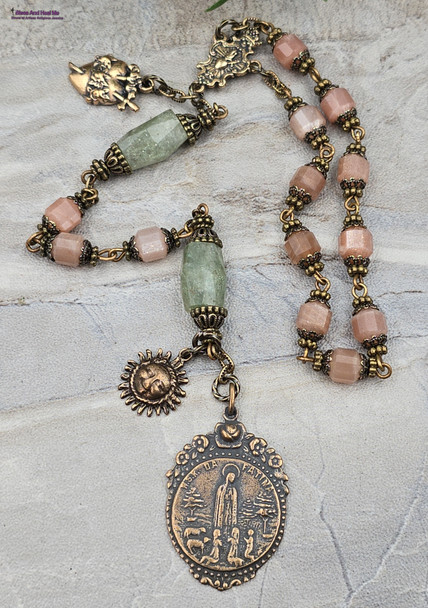 One-of-a-kind antique-style devotional chaplet featuring solid bronze medals of Fatima, Sacred Heart of Jesus, and Immaculate Heart of Mary, crafted with peach moonstone and green strawberry quartz prayer beads for Catholic meditation and reflection.