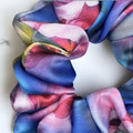 Tuhil Threads Large Vibrant Abstract Silky Satin Scrunchie. Luxurious large silky satin hair tie with a stunning abstract watercolor blend of rich blues, pinks, and purples for an eye-catching, gentle hold. Shop Tuhil Threads hair accessories.